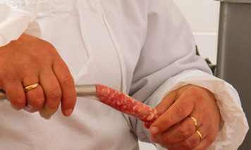man filling Italian sausages